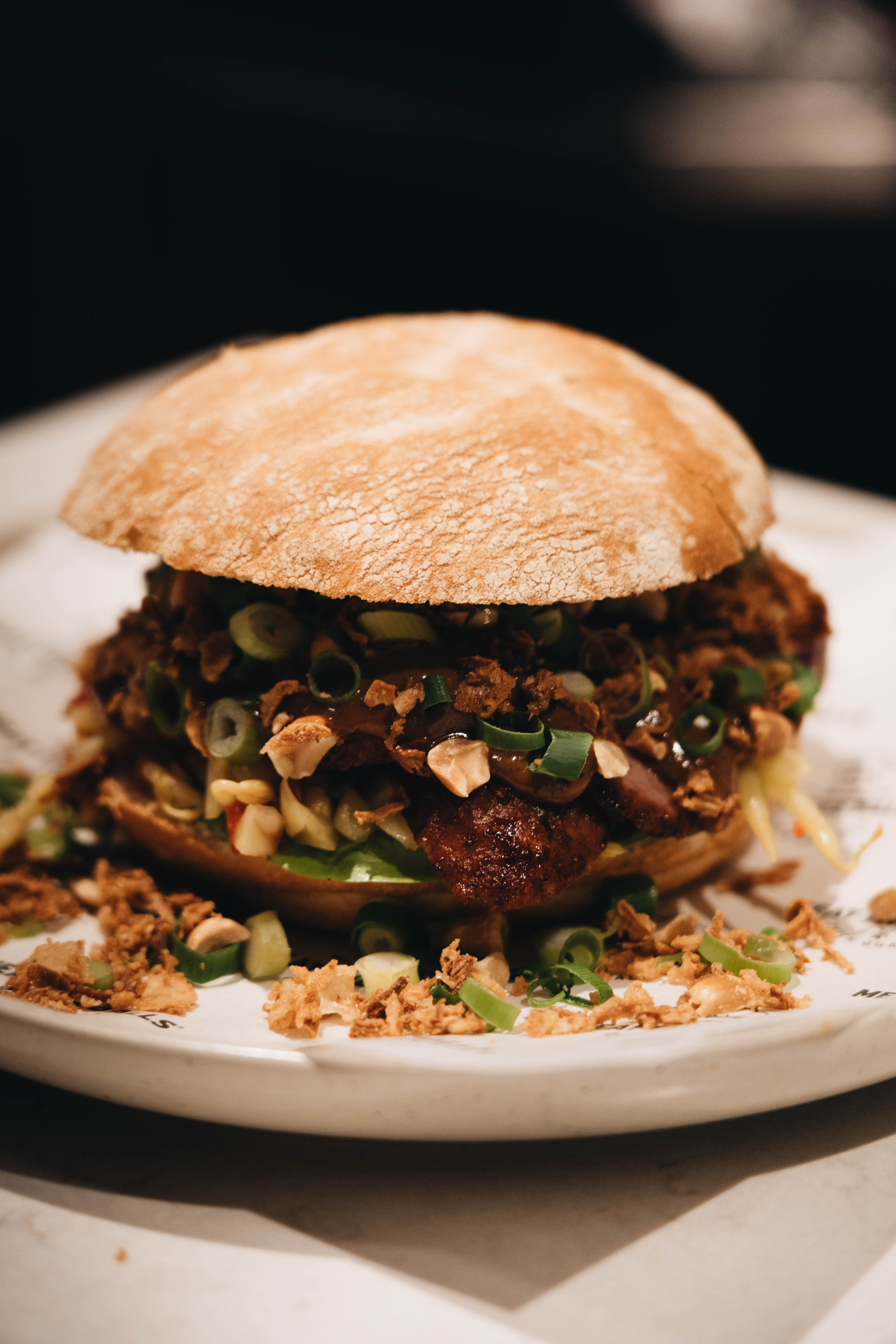 Luxe broodje bal met bal en groene topping op bord, Meat The Balls Amsterdam